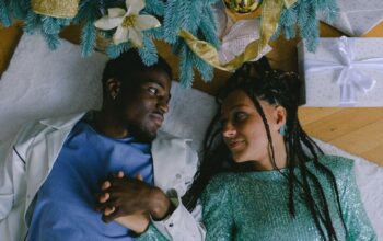 Couple are lying on the floor under a Christmas tree